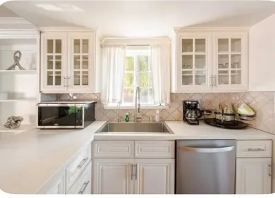 a white kitchen with a sink and a microwave at Spacious and Exclusive Oasis 6BR 3BA in Thousand Oaks