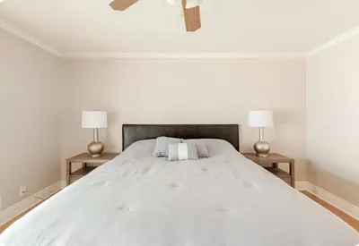 a white bedroom with a large bed with two lamps at Spacious and Exclusive Oasis 6BR 3BA in Thousand Oaks