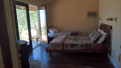 a bedroom with a bed and a sliding glass door at Secluded Oasis with View, and hot tub on 50 acres in Bodfish