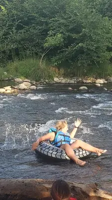 a woman laying on a raft in a river at Mountain Top Barn retreat with View in Bodfish