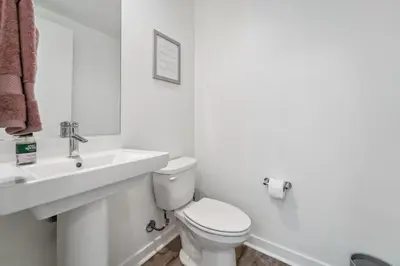 a white bathroom with a toilet and a sink at NoHo Modern Townhouse with Gorgeous Rooftop in Van Nuys