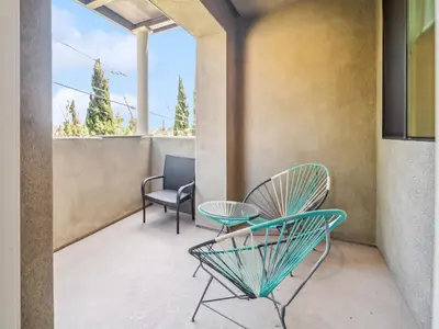 a patio with two chairs and a table at NoHo Modern Townhouse with Gorgeous Rooftop in Van Nuys