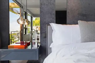 a bedroom with a bed and a table with a night stand at White Lotus by Stay Awhile Villas in Los Angeles