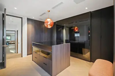 a kitchen with black cabinets and a black island at White Lotus by Stay Awhile Villas in Los Angeles