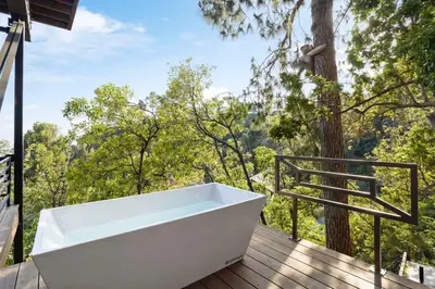 a bath tub on a deck with a tree at White Lotus by Stay Awhile Villas in Los Angeles