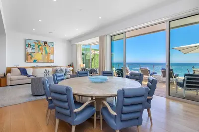 a dining room with a table and chairs and the ocean at Casa Mare by Stay Awhile Villas in Malibu Beach