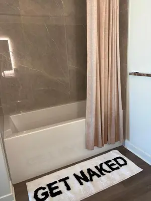 a bathroom with a bath tub with a get wanted rug at Aqua Marina Oceanfront Escape in Long Beach