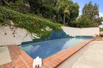 a swimming pool with a bench next to a wall at Allura Studio City Mediterranean with Private Pool in Los Angeles