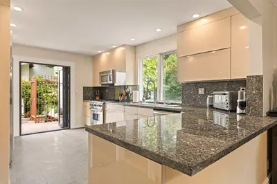 a large kitchen with granite counter tops and appliances at Allura Studio City Mediterranean with Private Pool in Los Angeles