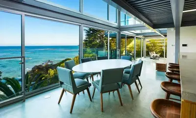 a dining room with a table and chairs and a view of the ocean at Broad Beach Wdirect Beach Access in Malibu