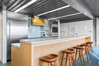 a kitchen with a counter with stools and a bar at Broad Beach Wdirect Beach Access in Malibu