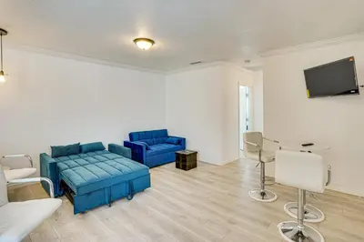 a living room with two blue couches and a flat screen tv at Between LA and Orange County Quiet Getaway with Patio in Pico Rivera