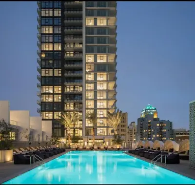 a swimming pool in front of a tall building at 2BR Panoramic City View!! in Los Angeles