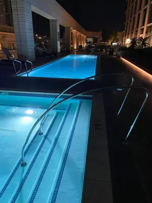 a swimming pool with blue water at night at Luxury Vacation Resort Studio Downtown LA in Los Angeles