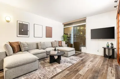 a living room with a couch and a tv at Spacious 2 Bedroom Condo in DTLA, Large Private Patio, Pets Welcomed in Los Angeles