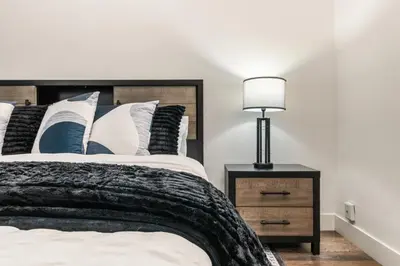 a bedroom with a bed and a lamp on a night stand at Spacious 2 Bedroom Condo in DTLA, Large Private Patio, Pets Welcomed in Los Angeles