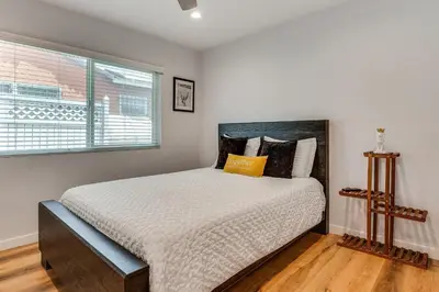 a bedroom with a large bed with a window at 4 Mi to SoFi Stadium Modern Home with Fenced Yard in Los Angeles