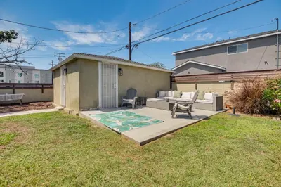 a patio with a table and chairs in a yard at 4 Mi to SoFi Stadium Modern Home with Fenced Yard in Los Angeles