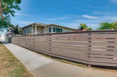 a wooden fence in front of a house at 4 Mi to SoFi Stadium Modern Home with Fenced Yard in Los Angeles