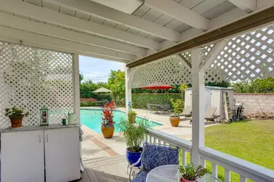 a white pergola over a patio with a pool at Cozy Couples Oasis with Pool 3 Mi to Disneyland! in Garden Grove