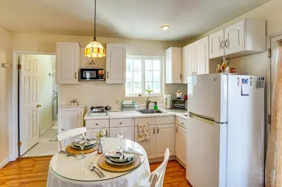 a kitchen with a table and a white refrigerator at Cozy Couples Oasis with Pool 3 Mi to Disneyland! in Garden Grove