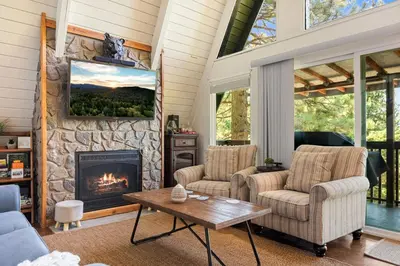 a living room with two chairs and a fireplace at Casa Huntsted A-Frame Cabin near Snow Valley in Running Springs