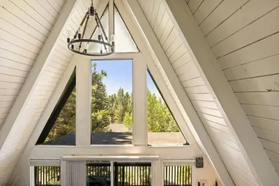 a large window in a house with a chandelier at Casa Huntsted A-Frame Cabin near Snow Valley in Running Springs