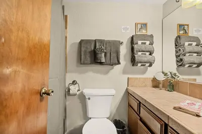 a bathroom with a toilet and a sink with towels at The Pinnacle steps to the ski lifts in Big Bear Lake