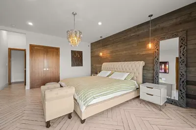 a bedroom with a bed and a chair in it at Coulson Street Retreat with pool BBQ and more in Los Angeles