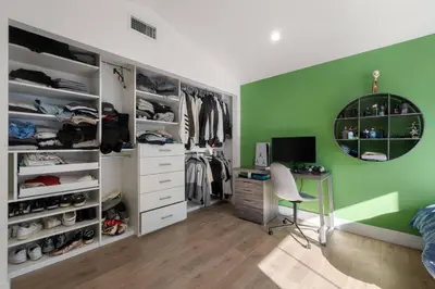 a bedroom with a desk and a green wall at Coulson Street Retreat with pool BBQ and more in Los Angeles