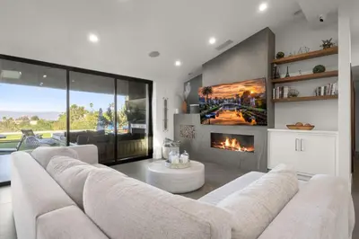 a living room with a white couch and a fireplace at Coulson Street Retreat with pool BBQ and more in Los Angeles