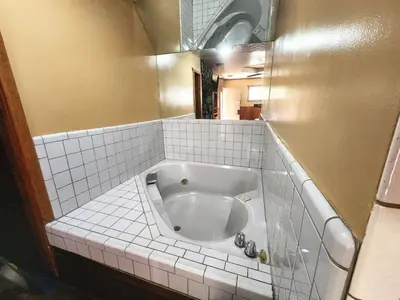 a bath tub in a tiled bathroom with a mirror at Creek Runner Lodge in Big Bear Lake