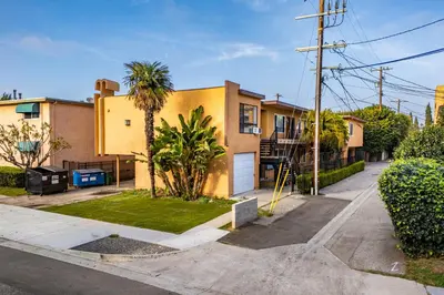 a house with a palm tree next to a street at Excellent 1BD Berryman#10 in Los Angeles