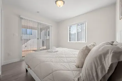 a white bedroom with a bed and a window at Niagara Haven in Burbank
