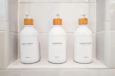 a group of three white bottles on a shelf in a bathroom at Weho Sunset Strip Hideaway And Casita in Los Angeles