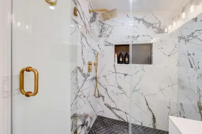 a bathroom with a marble shower with a glass door at 4BR Escape - Mtn Views Private BBQ in Thousand Oaks