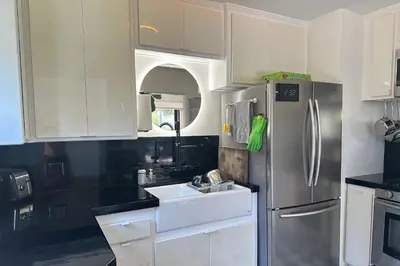a kitchen with white cabinets and a stainless steel refrigerator at Rad Stay Open Concept House in Mar Vista in Los Angeles