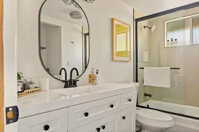 a bathroom with a sink and a toilet and a mirror at The Crown A-Frame Gated Central AC Lake Access in Lake Arrowhead
