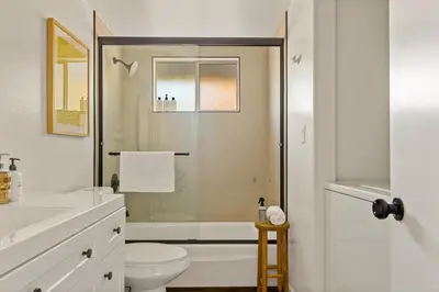 a white bathroom with a shower and a toilet at The Crown A-Frame Gated Central AC Lake Access in Lake Arrowhead