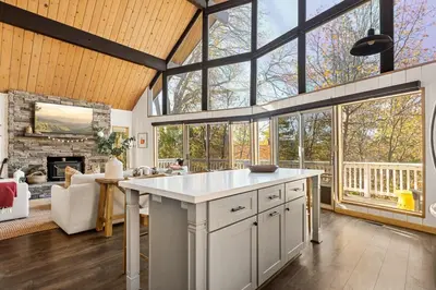 a kitchen with a large island in a room with windows at The Crown A-Frame Gated Central AC Lake Access in Lake Arrowhead