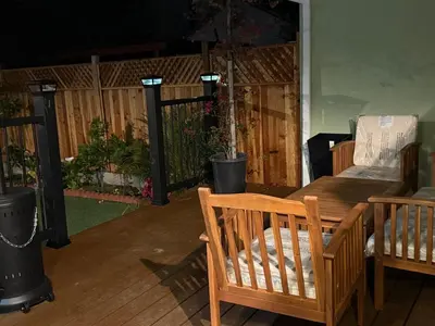 a patio with a table and chairs and a fence at Cheerful house with EV, Parking & backyard in Los Angeles
