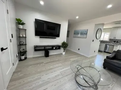 a living room with a flat screen tv on a wall at Cheerful house with EV, Parking & backyard in Los Angeles