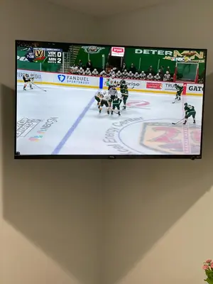 a television hanging on a wall with a hockey game at Modern Studio with Private Patio in Los Angeles