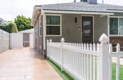 a white picket fence in front of a house at Modern Studio with Private Patio in Los Angeles