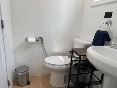 a white bathroom with a toilet and a sink at Modern Studio with Private Patio in Los Angeles