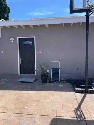a white building with a door and a plant at Cute Studio with AC and Backyard in Los Angeles
