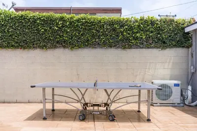 a ping pong table in front of a wall at Cute Studio with AC and Backyard in Los Angeles