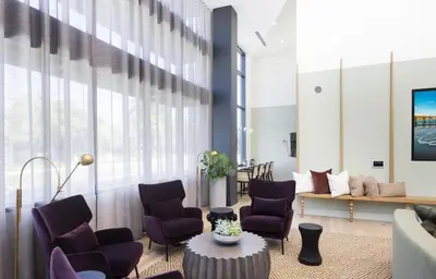 a living room with purple chairs and a table at Noho Alexan Modern 2bed Duo with FREE Parking in Garnsey