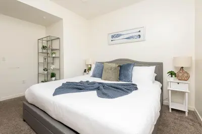 a bedroom with a large white bed with blue pillows at Hollywood Stars 2 Bedroom Apartment in Los Angeles