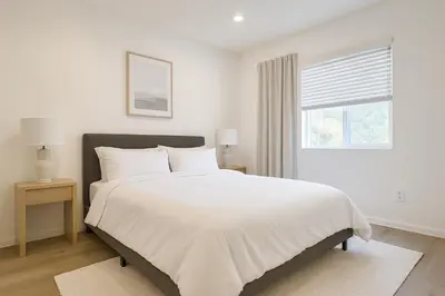 a white bedroom with a large bed and a window at Coast Malibu 2BR Escape in Malibu